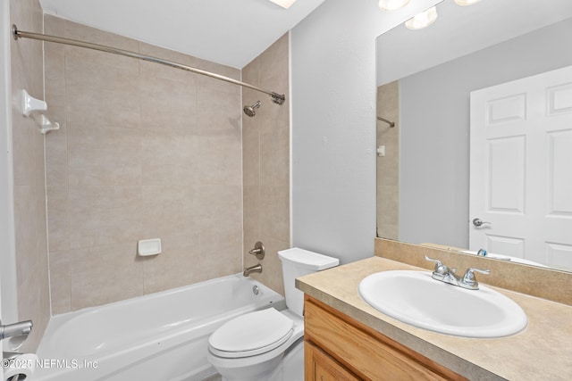 full bathroom with vanity, tiled shower / bath combo, and toilet