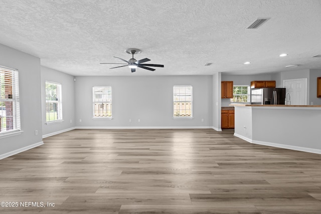 unfurnished living room with ceiling fan and hardwood / wood-style flooring