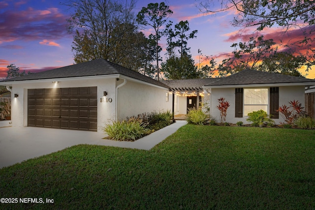 single story home featuring a yard and a garage