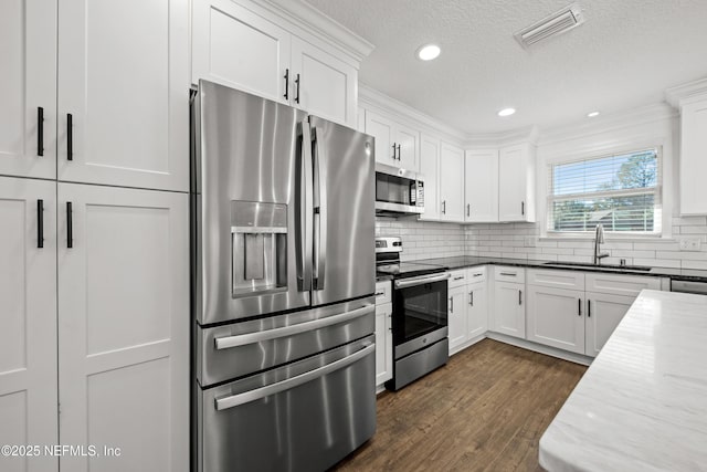 kitchen with stainless steel appliances, white cabinetry, and sink