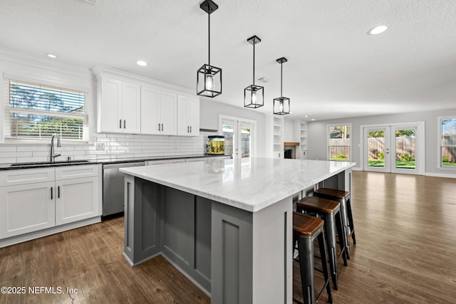 kitchen featuring dishwasher, a center island, french doors, and sink