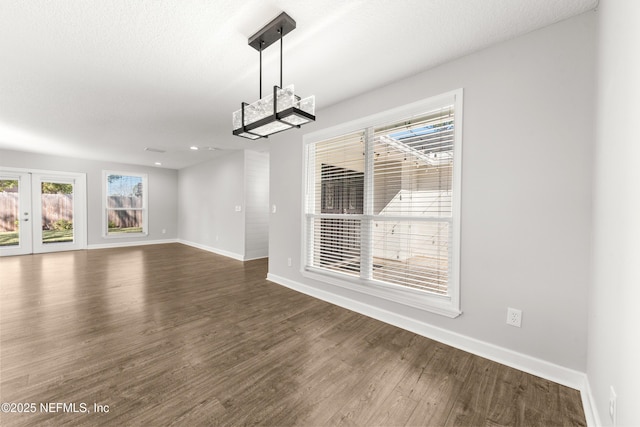 unfurnished dining area featuring french doors and dark wood-type flooring