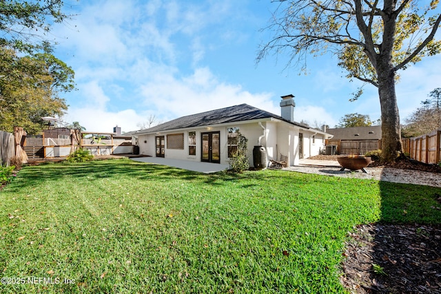 rear view of house featuring a yard, french doors, and a patio