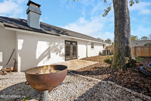 rear view of house with cooling unit, a patio area, and french doors