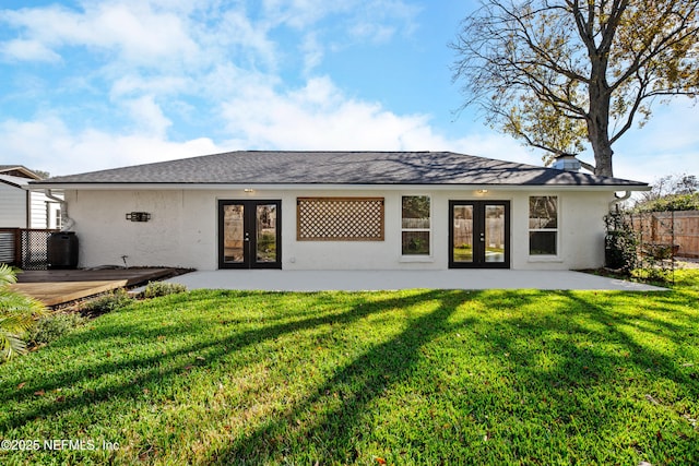 back of house featuring a lawn, a patio, and french doors