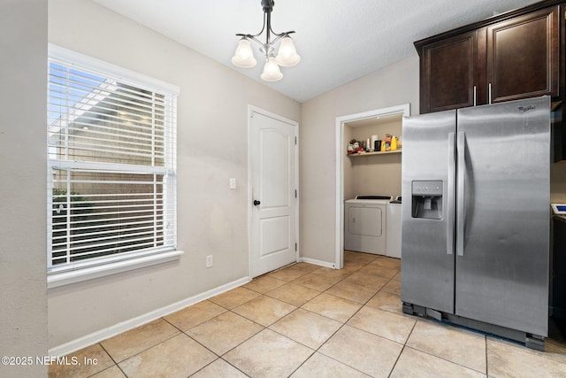 kitchen featuring dark brown cabinetry, independent washer and dryer, light tile patterned floors, a notable chandelier, and stainless steel fridge with ice dispenser