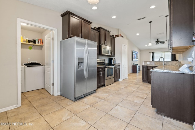 kitchen featuring light stone countertops, appliances with stainless steel finishes, dark brown cabinetry, ceiling fan, and washer and dryer