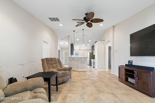 living room with ceiling fan, light tile patterned floors, and vaulted ceiling