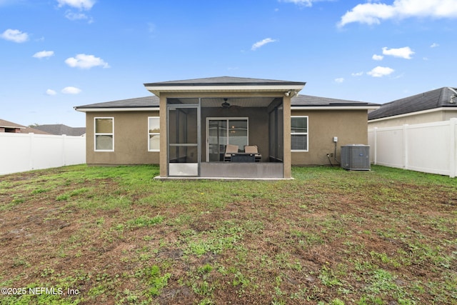 back of property with ceiling fan, a yard, cooling unit, and a sunroom