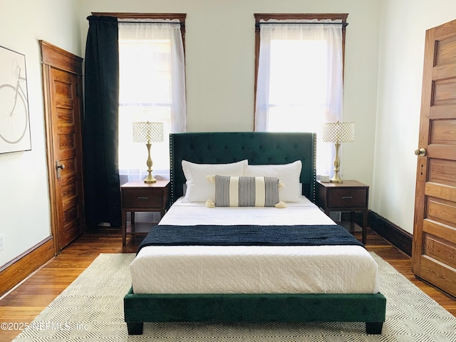 bedroom with wood-type flooring and multiple windows