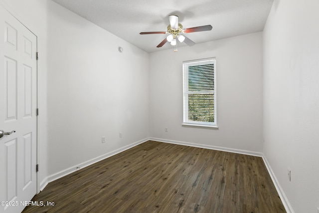 empty room with ceiling fan and dark hardwood / wood-style flooring