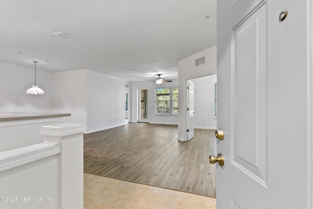 unfurnished living room featuring ceiling fan and light tile patterned flooring