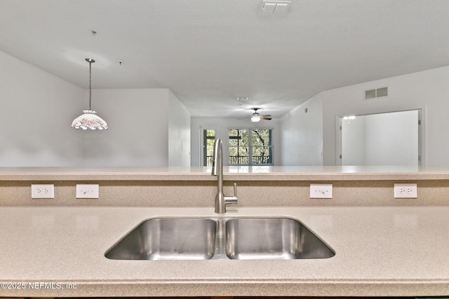 kitchen with decorative light fixtures, ceiling fan, and sink