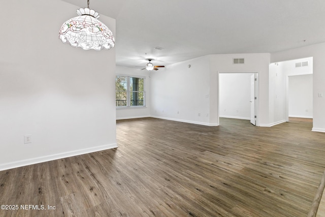 unfurnished living room featuring ceiling fan and dark wood-type flooring