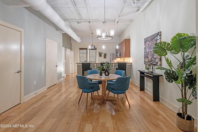 dining area featuring an inviting chandelier and light wood-type flooring