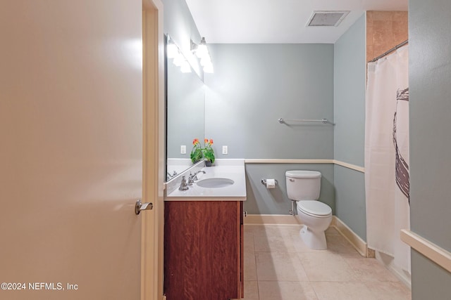 bathroom with tile patterned flooring, vanity, and toilet