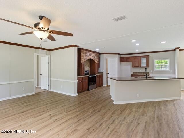 kitchen featuring hardwood / wood-style floors, sink, crown molding, and stainless steel electric range