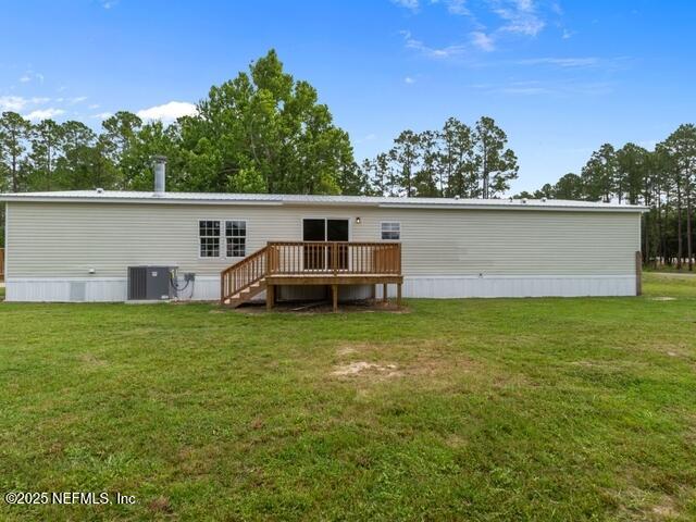 back of house with central air condition unit, a lawn, and a wooden deck