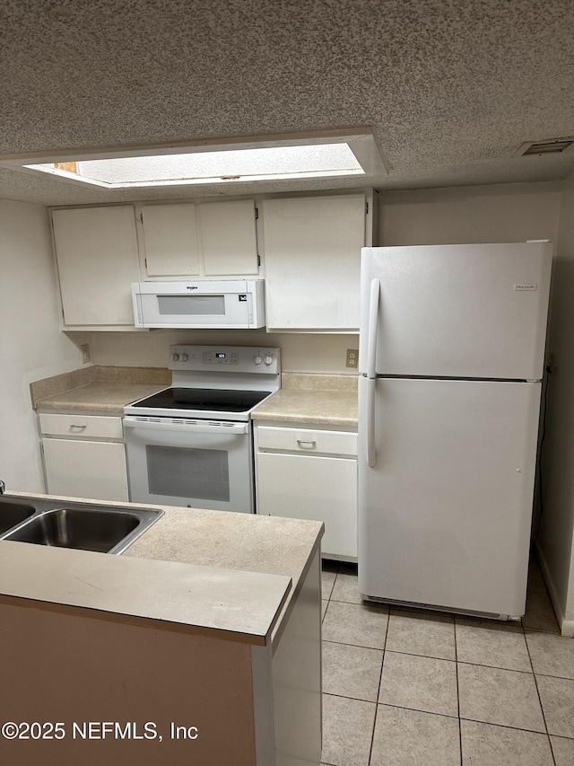 kitchen featuring white cabinetry, white appliances, sink, and light tile patterned floors