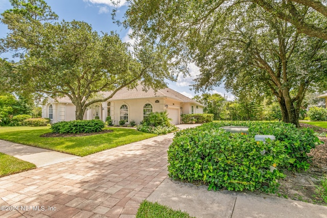 view of front of house featuring a garage and a front lawn