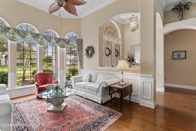 interior space with ceiling fan with notable chandelier, ornamental molding, and dark wood-type flooring