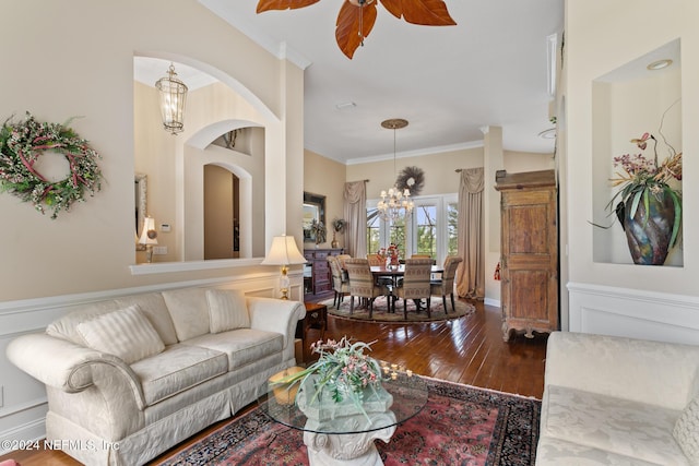 living room featuring ceiling fan with notable chandelier, hardwood / wood-style flooring, and crown molding