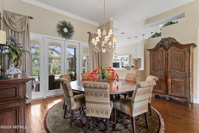 dining space with a chandelier, hardwood / wood-style floors, french doors, and crown molding