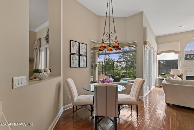 dining room with hardwood / wood-style floors, crown molding, and a chandelier