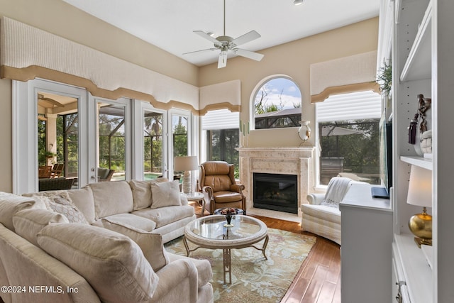 sunroom / solarium featuring ceiling fan and a high end fireplace