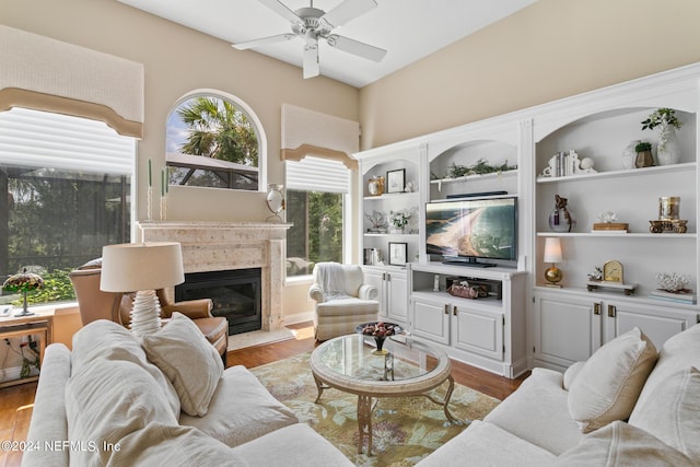 living room featuring hardwood / wood-style floors, ceiling fan, and a high end fireplace