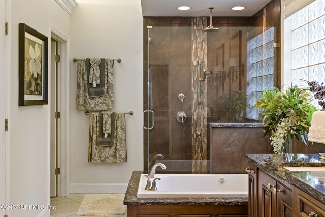 bathroom featuring tile patterned flooring, vanity, and plus walk in shower