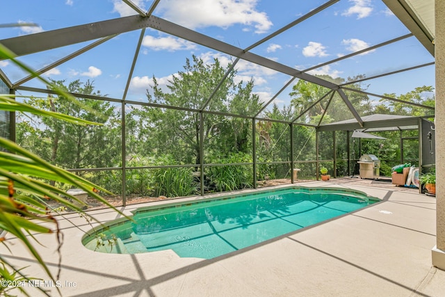 view of pool featuring area for grilling, a lanai, and a patio area