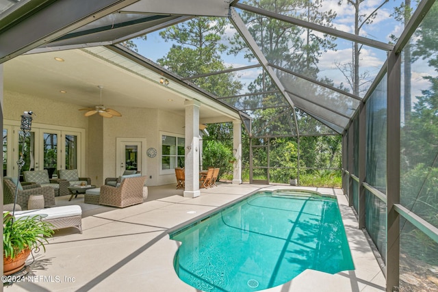 view of pool with ceiling fan, french doors, a lanai, an outdoor hangout area, and a patio area