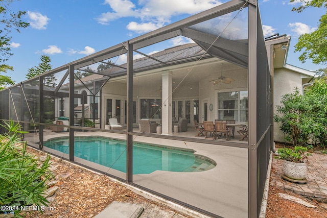 view of pool featuring glass enclosure, ceiling fan, and a patio