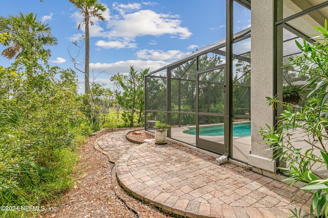 view of patio featuring a lanai