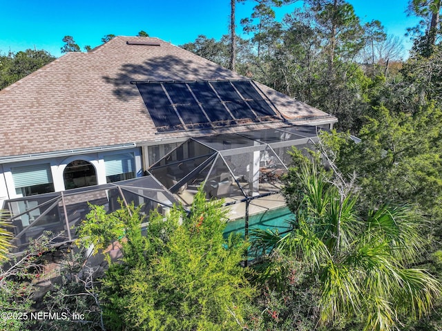 exterior space featuring glass enclosure and solar panels