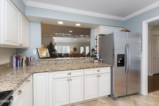 kitchen featuring white cabinetry, light stone counters, stainless steel fridge, light tile patterned flooring, and ornamental molding