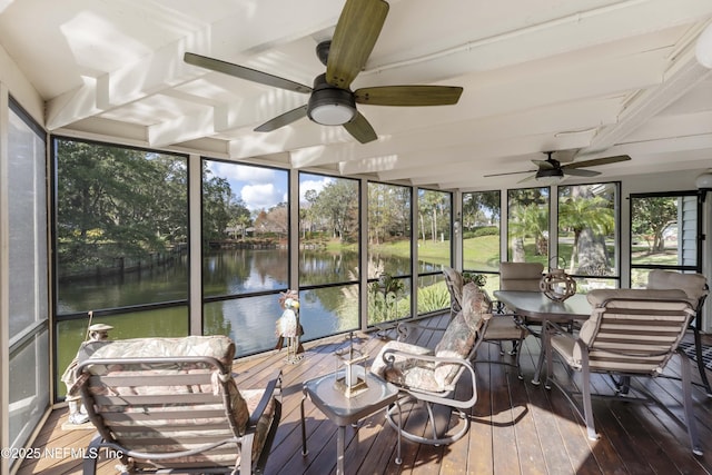 sunroom with ceiling fan and a water view