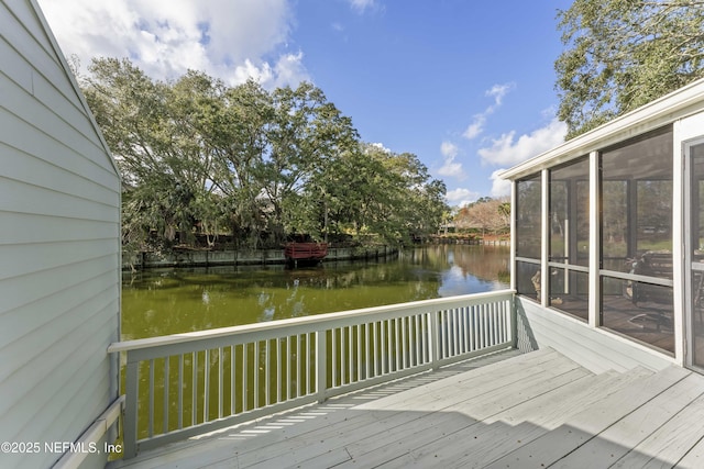 wooden terrace featuring a water view and a sunroom