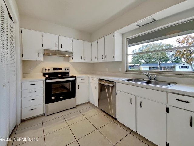 kitchen with sink, white cabinetry, stainless steel appliances, and light tile patterned floors