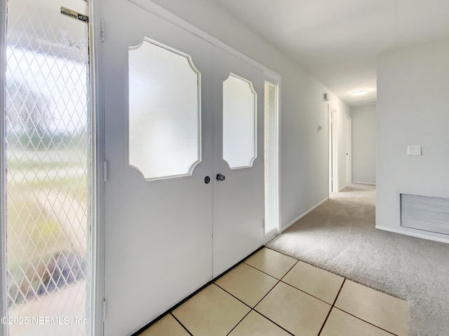 hall with light tile patterned floors and plenty of natural light