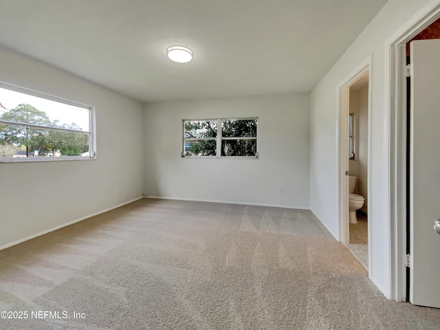 carpeted spare room featuring a healthy amount of sunlight