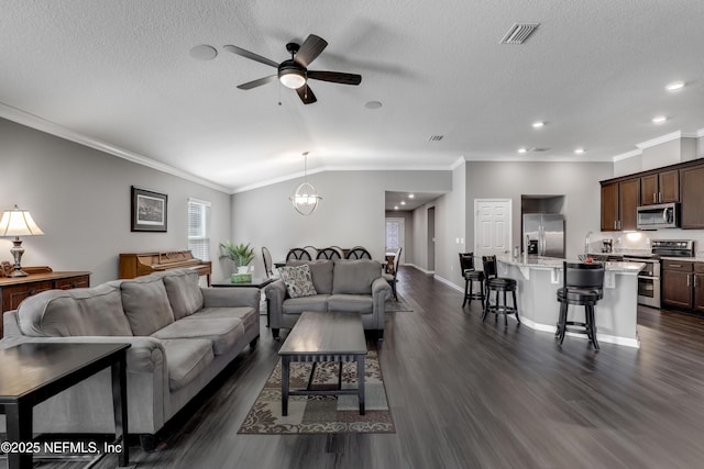 living room featuring a textured ceiling, ceiling fan with notable chandelier, vaulted ceiling, and crown molding