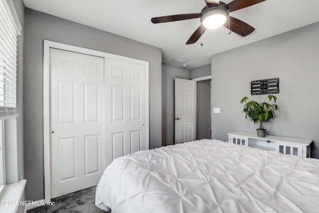 carpeted bedroom with ceiling fan and a closet