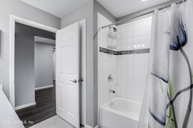 bathroom featuring a textured ceiling, hardwood / wood-style flooring, and shower / bath combo with shower curtain