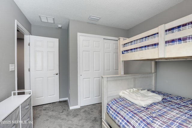 carpeted bedroom with a textured ceiling and a closet