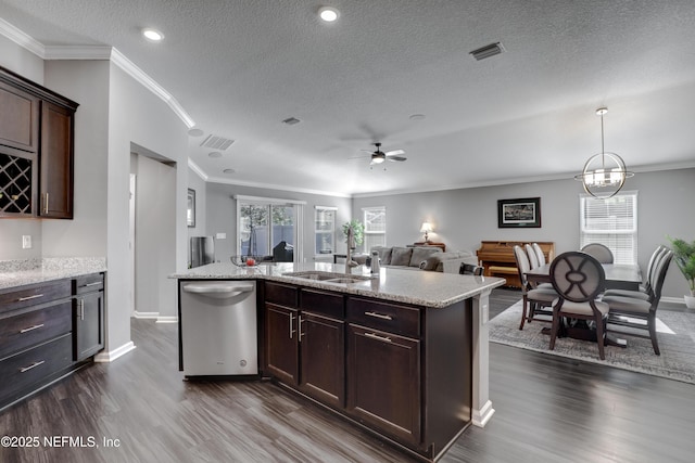 kitchen with a kitchen island with sink, stainless steel dishwasher, and a textured ceiling