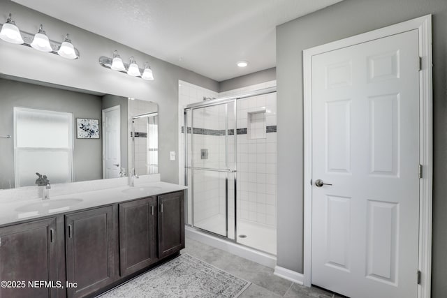 bathroom featuring tile patterned flooring, vanity, and a shower with door