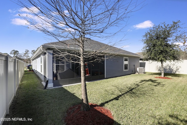 back of house featuring a sunroom, central air condition unit, and a yard