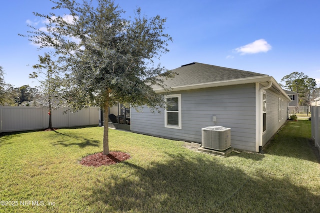 rear view of property with a lawn and central AC